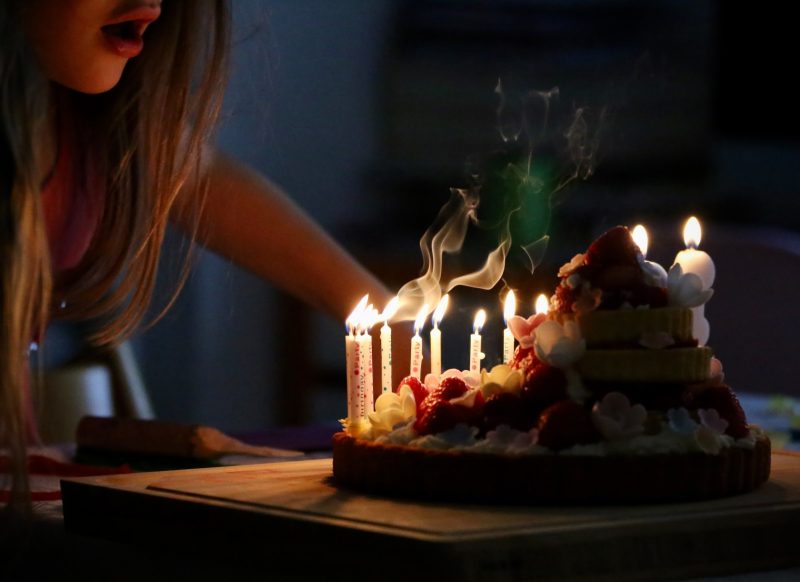 Девушка и праздничный торт со свечами