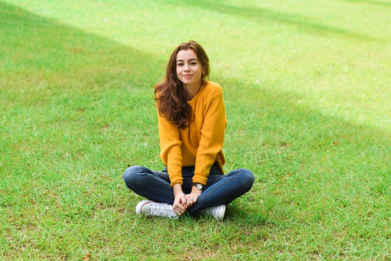 Красивая девушка сидит на траве