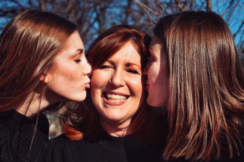 Дочери целуют маму