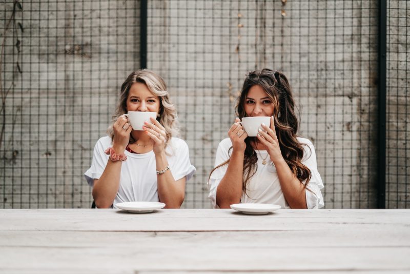 Две сестры пьют чай за столом